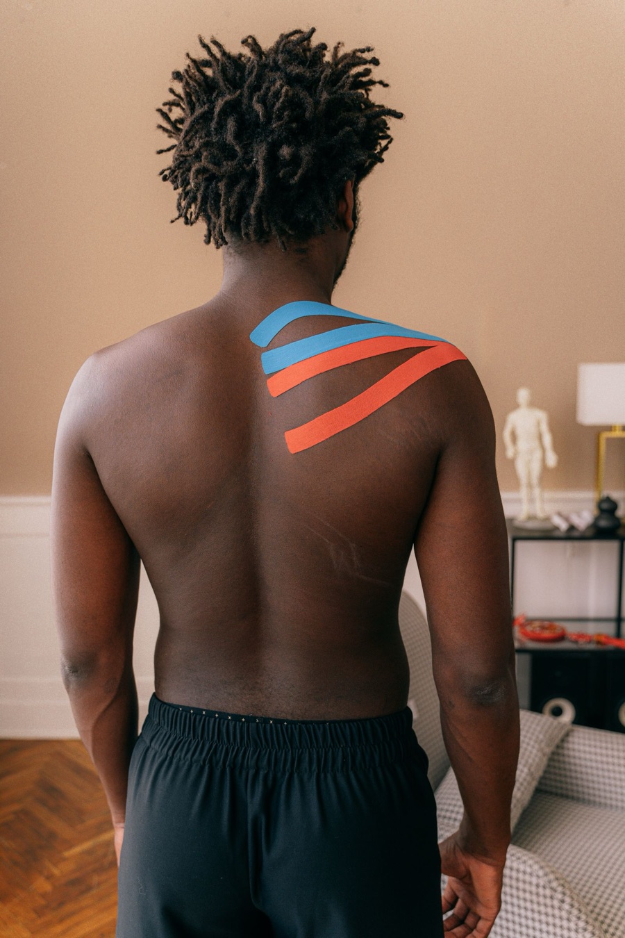 Atleta con taping kinesiologico sulla spalla